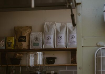 "Close-up of organic teas and sustainably sourced coffee bags neatly arranged on a shelf in an eco-friendly trailer café."